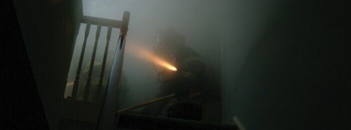 Firefighter in smoke with flashlight